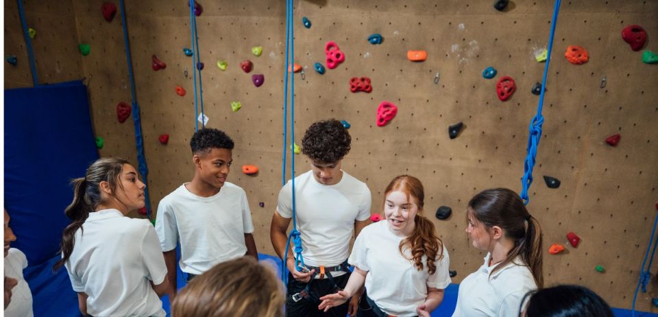 Adolescents preparing for indoor rock climbing