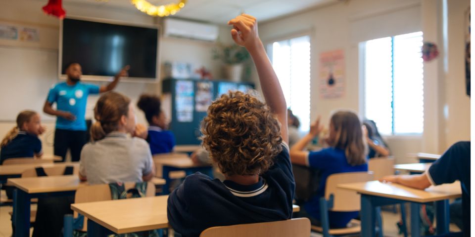 Middle schoolers engaging with their teacher in class