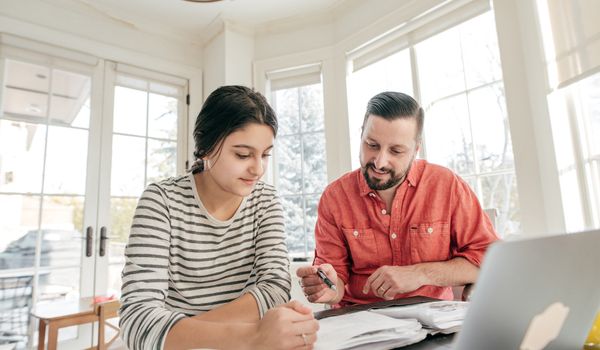 Teen girl and her dad doing homework together