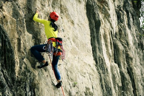 Thumbnail for Teen rock climbing with support and a helmet